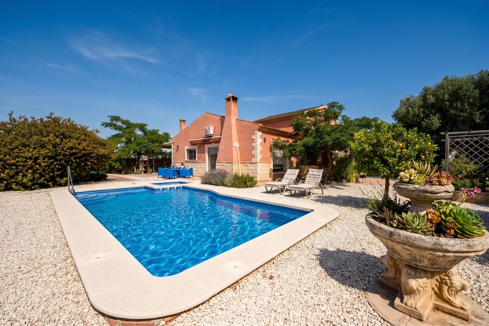The private pool with white gravel, potted citrus and the sierras behind